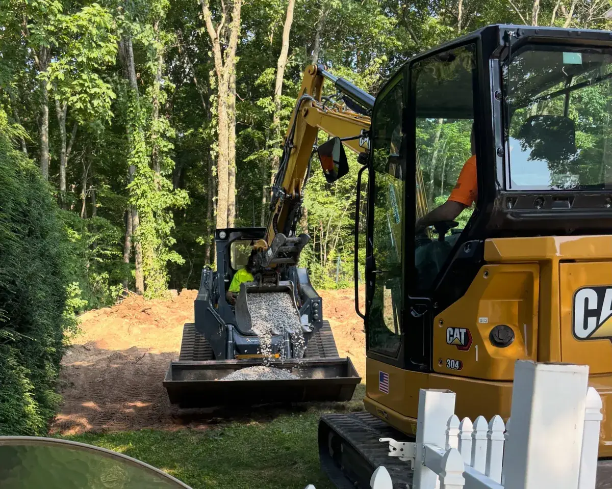 Gregory Construction crew doing site prep with an excavator and skid steer